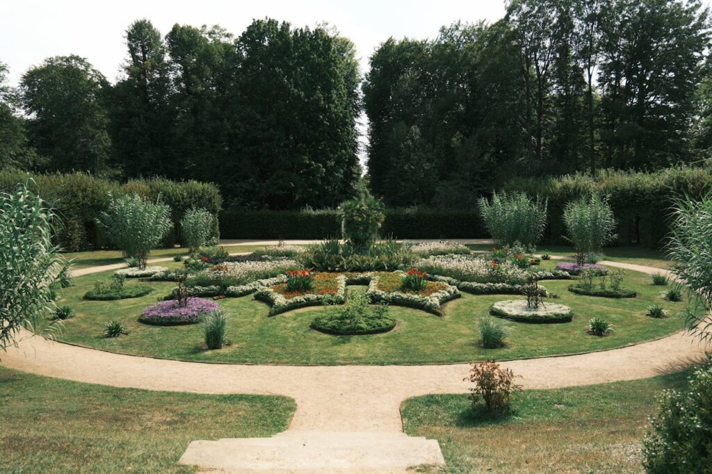 A beautifully landscaped symmetrical garden with lush greenery and colorful flowers.